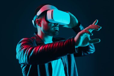 VR kulaklıklı adam havaya dokunuyor.