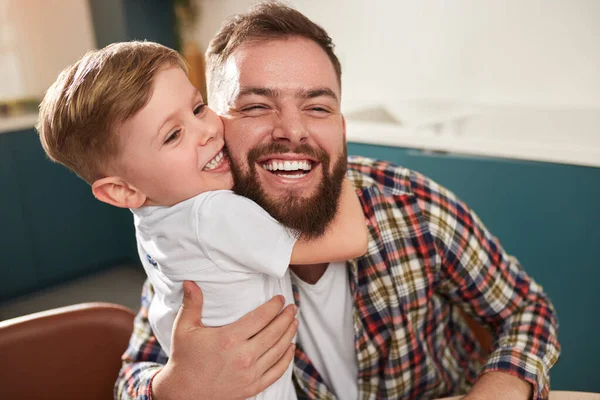 Dzieciak obejmujący szczęśliwego ojca w domu — Zdjęcie stockowe