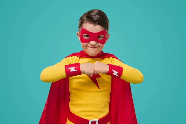 Мальчик в костюме супергероя смотрит в камеру в студии — стоковое фото