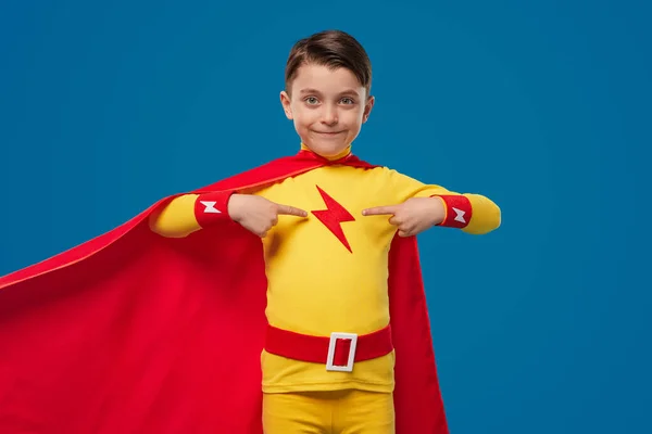 Stolzer Superheldenjunge zeigt auf Brust — Stockfoto