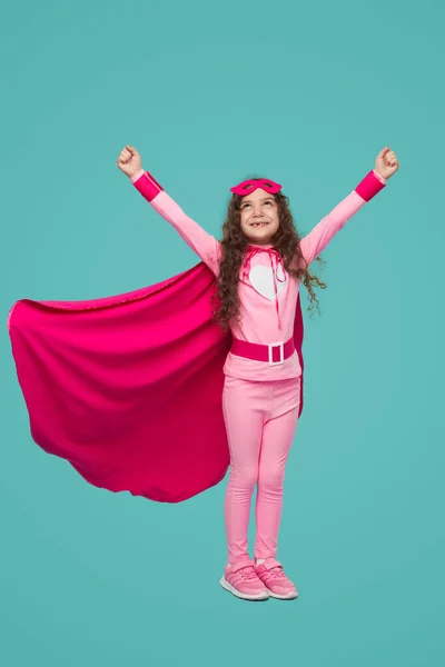 Щаслива супергеройська дівчина літає з піднятими руками — стокове фото