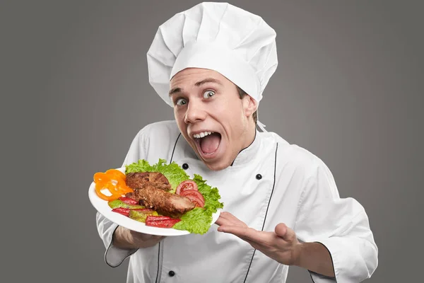 Funny hilarious chef demonstrating delicious dish in restaurant Stock Image