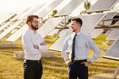 Güneş enerjisi istasyonunda iletişim kuran iş adamları