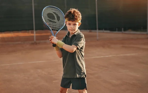 Malý chlapec hraje tenis na hřišti — Stock fotografie