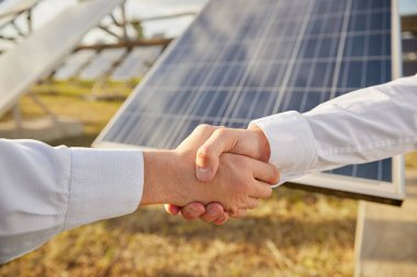 İş adamları güneş enerjisi santrali yakınlarında el sıkışıyor
