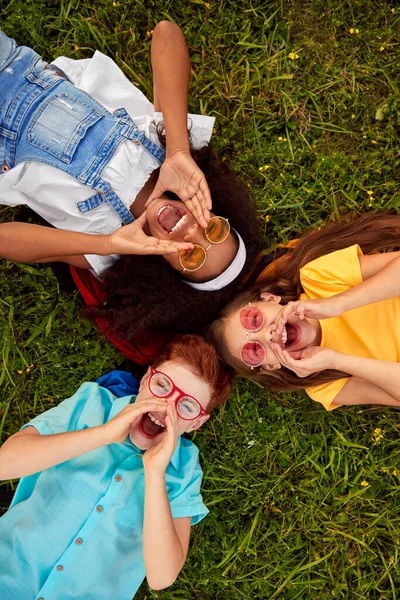 Happy diverse kids lying on grass and screaming — Stock Fotó