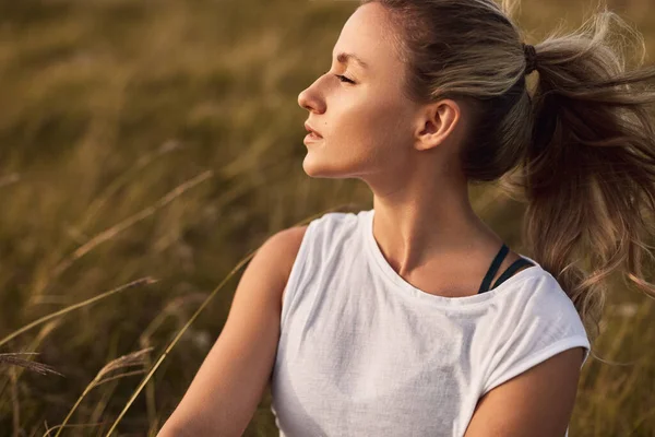 Jonge vrouw rustend in de zomer veld — Stockfoto