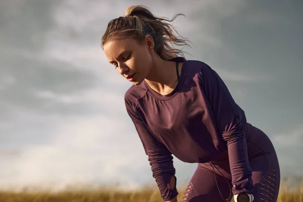 Esausta jogger femminile avendo pausa nel campo — Foto Stock