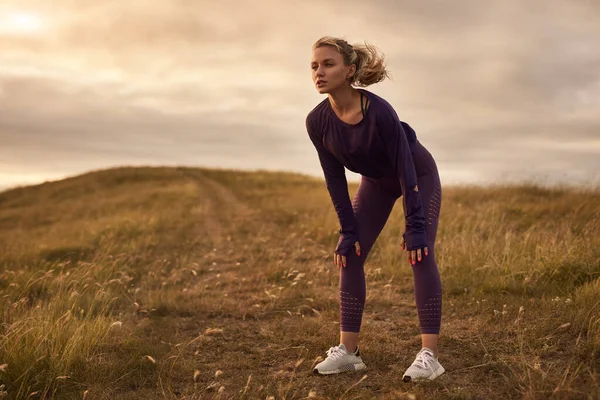 Mulher desportiva descansando durante o treino na natureza — Fotografia de Stock