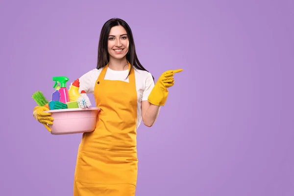 Fröhliche Hausfrau mit Putzmitteln zur Seite — Stockfoto