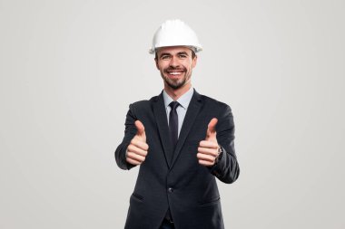 Başparmak kaldıran kasklı mutlu iş adamı