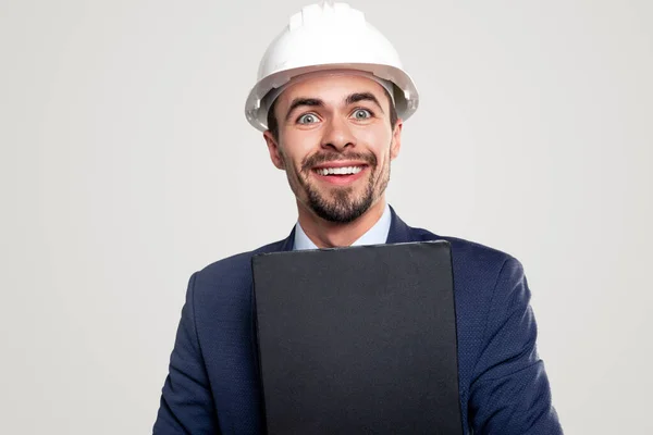 Cheerful construction architect with clipboard looking at camera — Stock Photo, Image