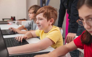 Mutlu çocuk sınıfta bilgisayar bilimi öğreniyor.