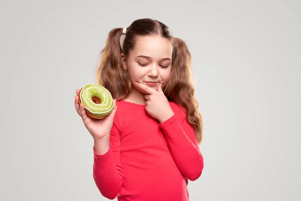 Ragazza pensierosa con ciambella gustosa — Foto Stock