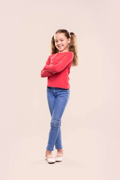 Usmívající se dívka v ležérní oblečení se zkříženými pažemi — Stock fotografie
