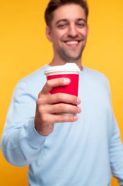 Genç adam kameraya kahve ikram ediyor.
