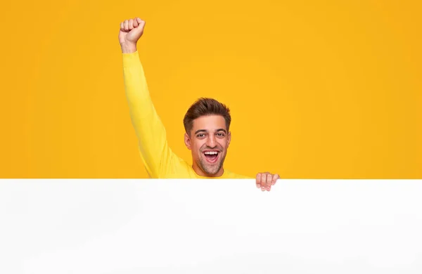Opgewonden man met vuist omhoog tonen blanco banner — Stockfoto