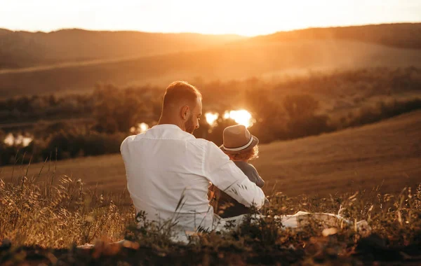 Vader en kind genieten van zonsondergang in de natuur — Stockfoto