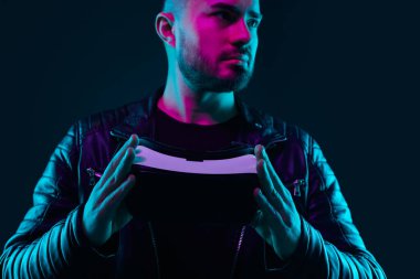 VR kulaklıklı, neon ışıklı, ciddi bir adam.