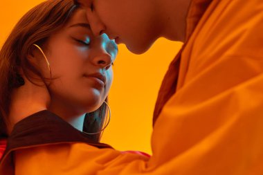 Teenager kissing girlfriend in neon light clipart