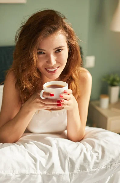 아침에 침대에서 커피를 마시는 행복 한 여성 — 스톡 사진