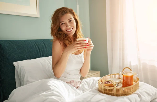 Jong vrouwtje ontbijten op bed — Stockfoto
