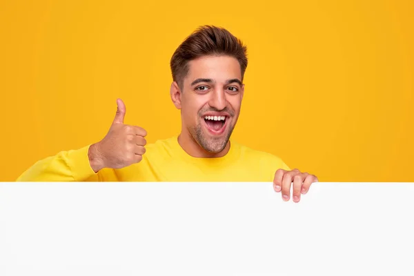 Веселий чоловік з порожнім банером показує великий палець вгору — стокове фото