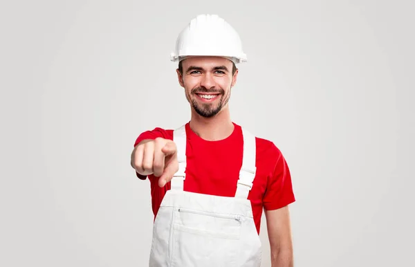 Smiling builder in workwear pointing at camera — Stock Photo, Image