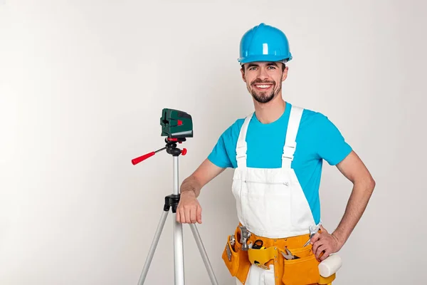 Glücklicher Baumeister mit Laserwaage — Stockfoto