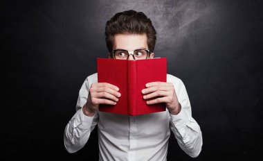 Kırmızı kitabın arkasına saklanan komik öğrenci.