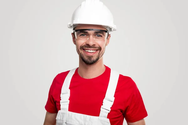 Joyeux constructeur en casque et lunettes de protection — Photo