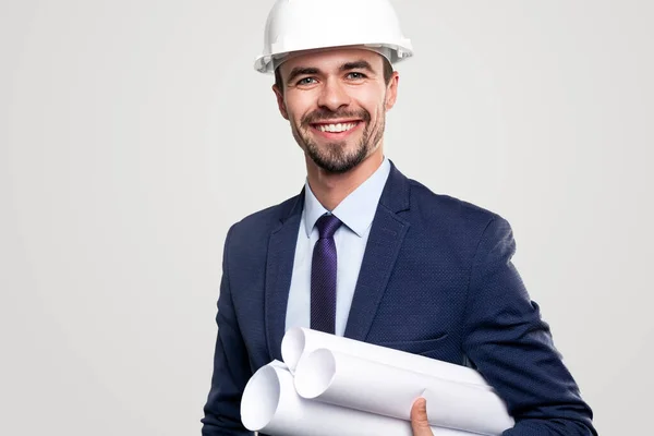 Smiling construction engineer with blueprints looking at camera — Stock Photo, Image
