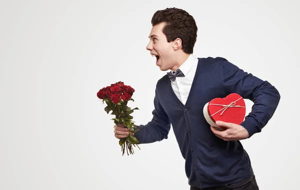 Feliz homem amoroso com flores e caixa de presente — Fotografia de Stock