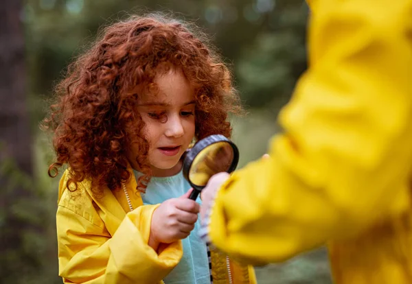 Little girl with magnifier exploring nature — Stock Photo, Image