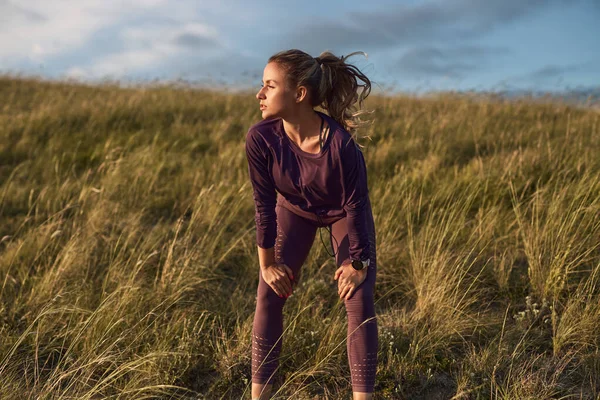 Donna sportiva che ha pausa durante la corsa in campo — Foto Stock