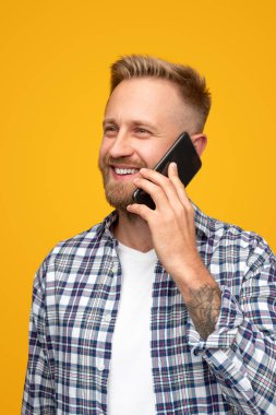 Sakallı adam akıllı telefondan konuşuyor.