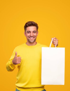 Satın almayı onaylayan neşeli genç adam.