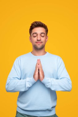 Genç adam sımsıkı sarılıp meditasyon yapıyor.