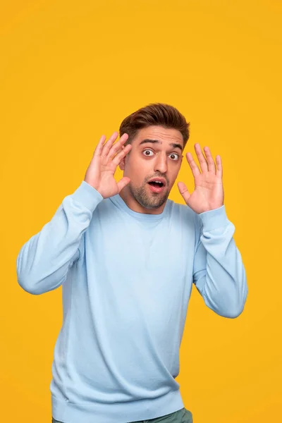 Hombre joven asustado mirando a la cámara — Foto de Stock