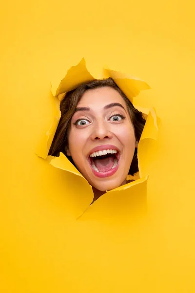 Mulher excitada gritando de buraco no papel — Fotografia de Stock