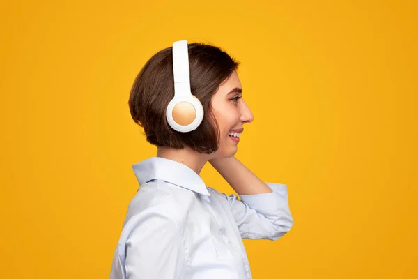 Mujer feliz disfrutando de la música a través de auriculares — Foto de Stock