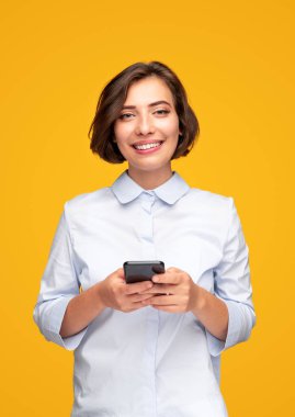 Akıllı telefon kullanan neşeli genç bayan.