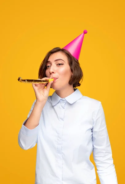 Jeune femme soufflant bruyant pendant la célébration de l'anniversaire — Photo