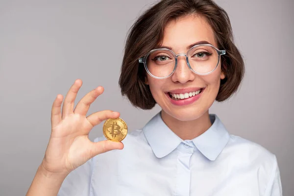 Χαρούμενη γυναίκα που δείχνει bitcoin και χαμογελά — Φωτογραφία Αρχείου