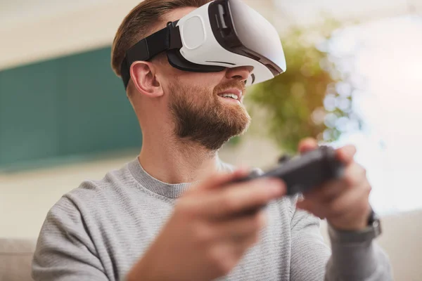 Homem alegre no fone de ouvido VR desfrutando de videogame interativo — Fotografia de Stock