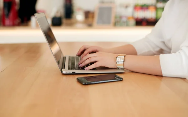 Женщина, работающая на ноутбуке за столом — стоковое фото