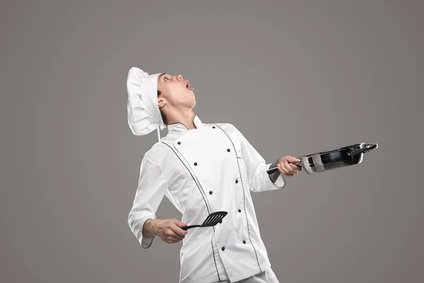 Chef engraçado com frigideira e espátula olhando para cima — Fotografia de Stock