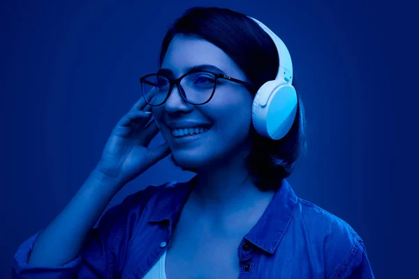 Mujer alegre en auriculares escuchando música — Foto de Stock