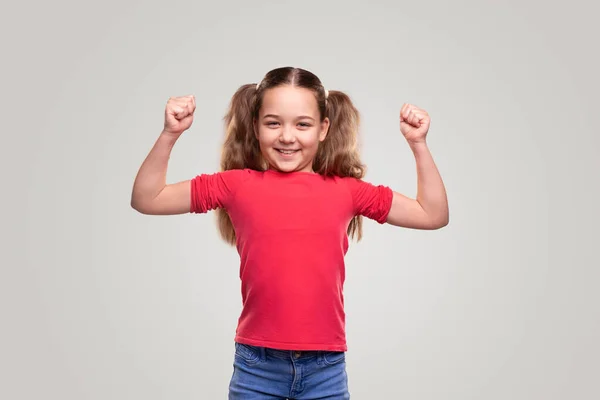 Strong child smiling and showing biceps — Stock Photo, Image