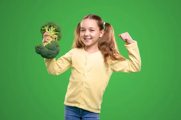 Ragazza allegra con broccoli mostrando muscoli — Foto Stock